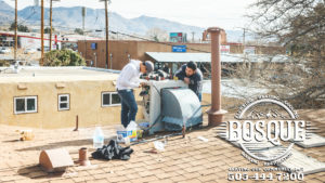 two guys on a roof working on a broken ac unit in albuquerque new mexico